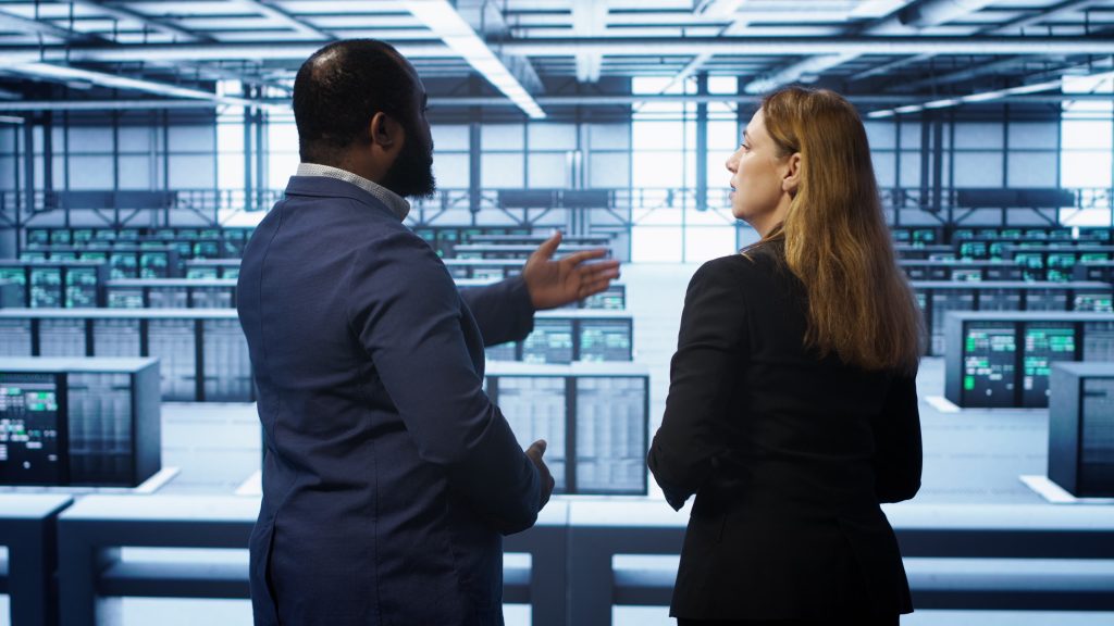 Two IT professionals reviewing server infrastructure in a data centre