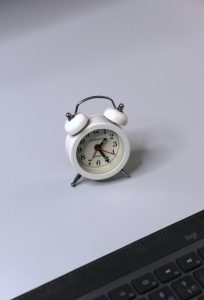 Alarm clock on top of a laptop, symbolizing time-critical response to a cybersecurity incident
