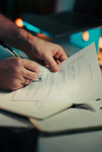 Signing an insurance document, representing cybersecurity insurance policy requirements