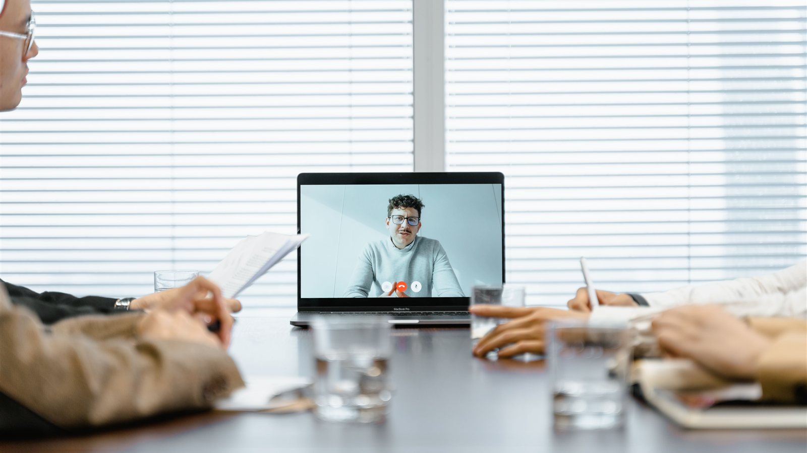 Team members on a video call in a modern conference room using a Teams Rooms meeting bar setup