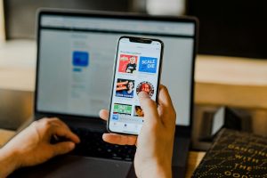Person using a smartphone and laptop together